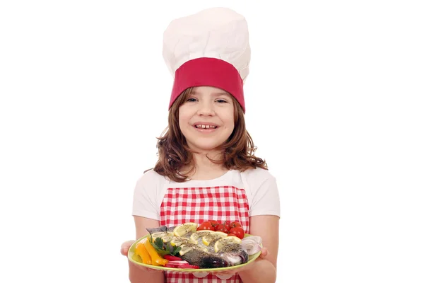 Feliz niña cocinero con pescado de trucha preparado en el plato —  Fotos de Stock