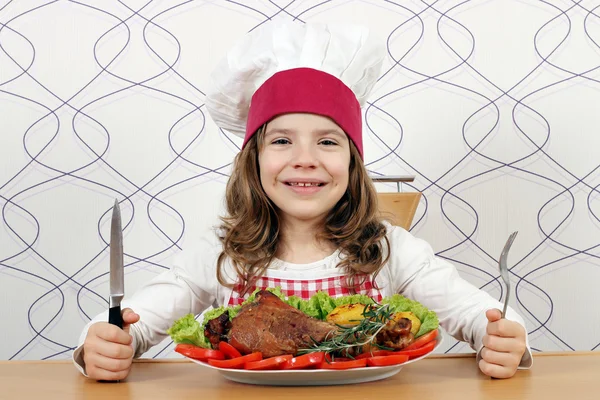 Bambina cuoca con grande coscia di tacchino sul tavolo — Foto Stock
