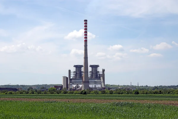 Wärmekraftwerk auf grünem Weizenfeld — Stockfoto