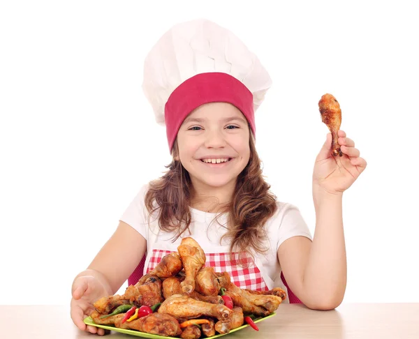 Beautiful little girl cook with chicken drumstick — Stock Photo, Image