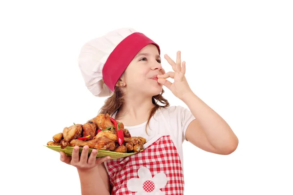 Lycklig liten flicka laga mat med kyckling Kycklingben och ok hand tecken — Stockfoto