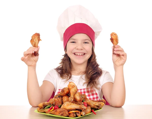 Heureuse petite fille cuisinier tenant pilons de poulet — Photo