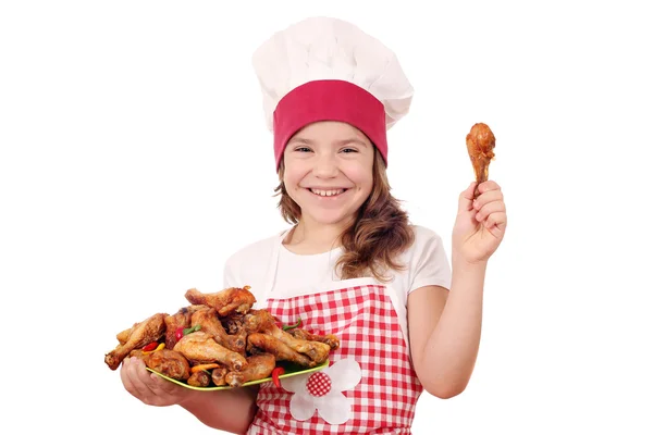 Heureux petite fille cuisinier avec poulet pilon — Photo