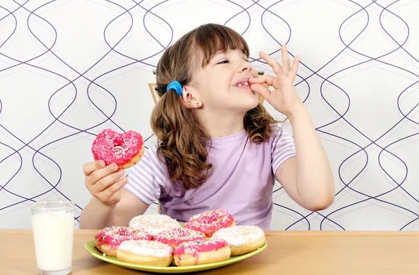 小さな女の子は、甘いドーナツをお楽しみください。 — ストック写真