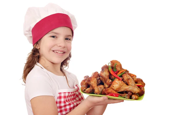 Felice bambina cuoca con coscia di pollo — Foto Stock