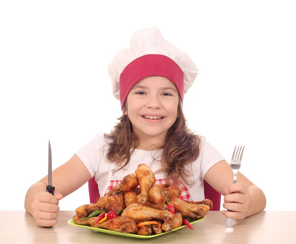 Petite fille cuisinier avec du tambour de poulet sur plaque prête pour le déjeuner — Photo