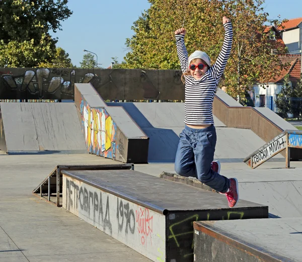 Glückliches kleines Mädchen springt im Skatepark — Stockfoto