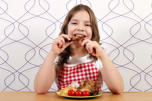Πεινασμένος κορίτσι τρώει φτερούγες κοτόπουλου — Φωτογραφία Αρχείου