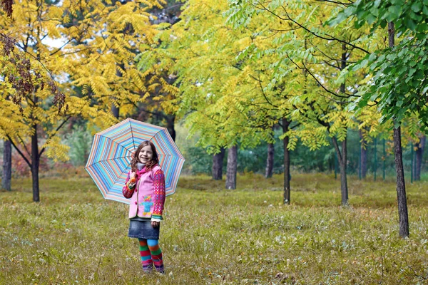 Schöne kleine Mädchen mit Regenschirm im Park Herbstsaison — Stockfoto