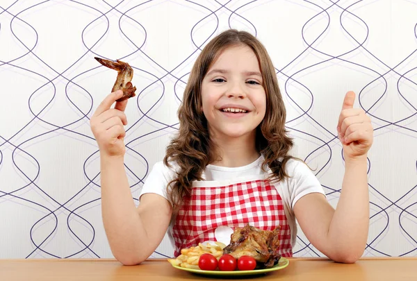 Felice bambina con ali di pollo arrosto e pollice in su — Foto Stock