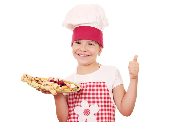 Menina feliz cozinhar com crepes e polegar para cima — Fotografia de Stock