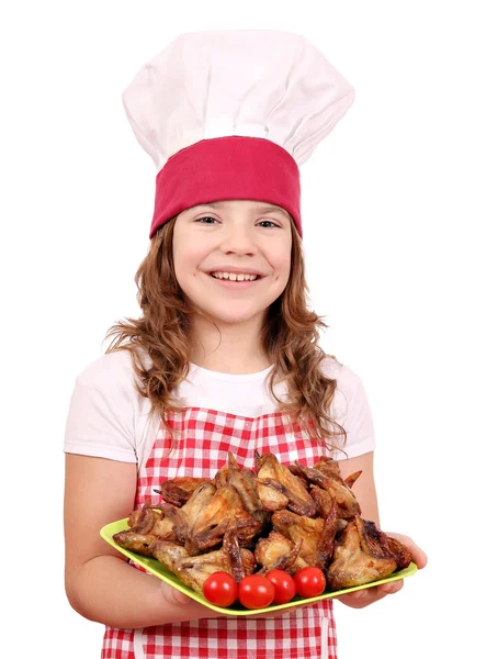Щаслива маленька дівчинка готує з курячими крилами — стокове фото