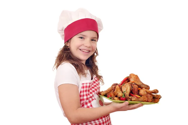 Happy little girl cook with roasted chicken drumsticks — Stock Photo, Image