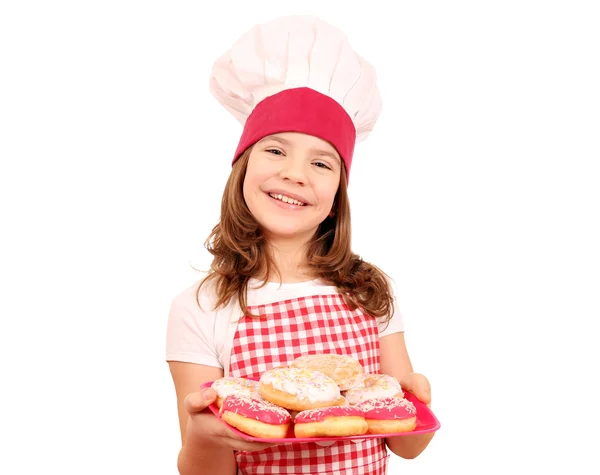 Menina feliz cozinhar com donuts doces no prato — Fotografia de Stock