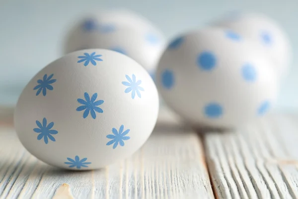 Uova di Pasqua blu e bianche su sfondo di legno — Foto Stock