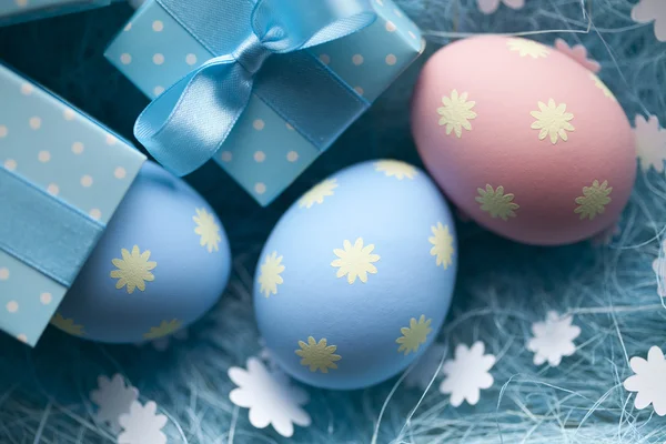 Uova di Pasqua e scatola regalo su sfondo blu — Foto Stock