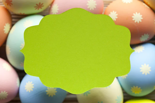 Etiqueta verde e muitos ovos coloridos no fundo — Fotografia de Stock