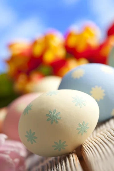 Βαμμένα αυγά του Πάσχα και πολύχρωμα λουλούδια σε φόντο του ουρανού — Φωτογραφία Αρχείου