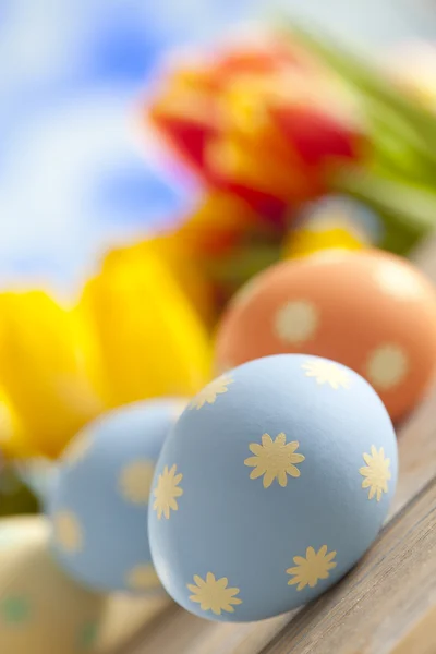 Uova di Pasqua dipinte e fiori primaverili colorati sul backgroun cielo — Foto Stock