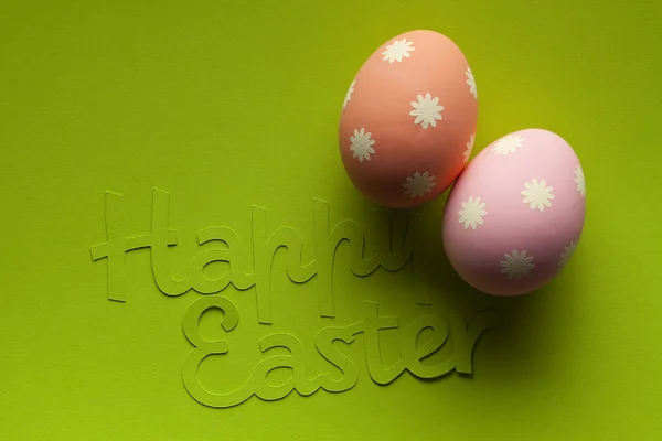 Two Easter eggs and inscription on green paper background — Stock Photo, Image