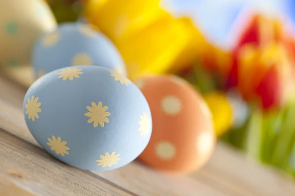 Huevos de Pascua pintados y flores de primavera coloridas en el fondo del cielo —  Fotos de Stock