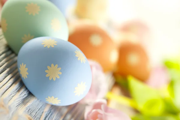 Ovos de Páscoa em cores pastel e flores de primavera — Fotografia de Stock