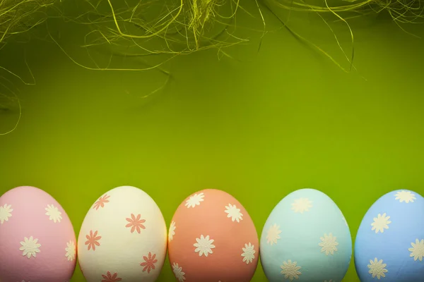 A színes húsvéti tojásokat és zöld háttér — Stock Fotó