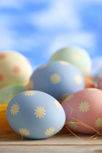 Uova di Pasqua in colore pastello su sfondo cielo blu — Foto Stock