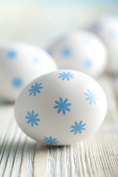 Huevos blancos con patrón azul sobre fondo de madera —  Fotos de Stock