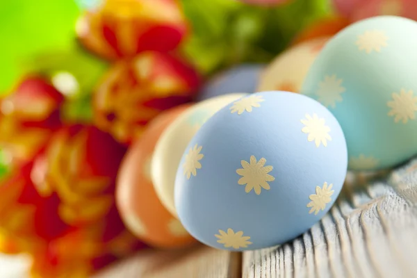 Festett húsvéti tojásokat, pasztell színek és a színes tavaszi virágok — Stock Fotó