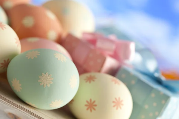 Uova di Pasqua e scatole regalo in colori pastello sul backgrou cielo blu — Foto Stock