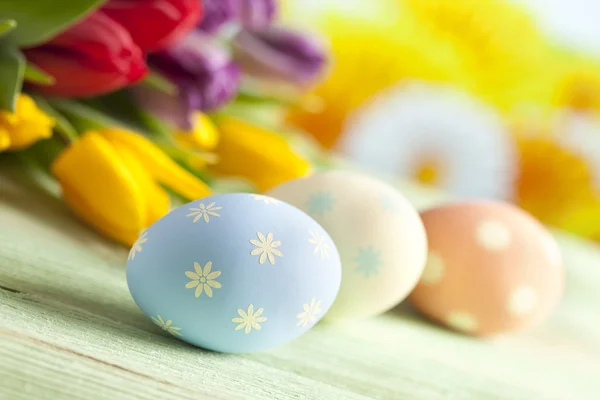 Bunte Ostereier und Frühlingsblumen — Stockfoto