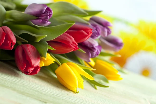 Colorful tulips on wooden table Royalty Free Stock Photos