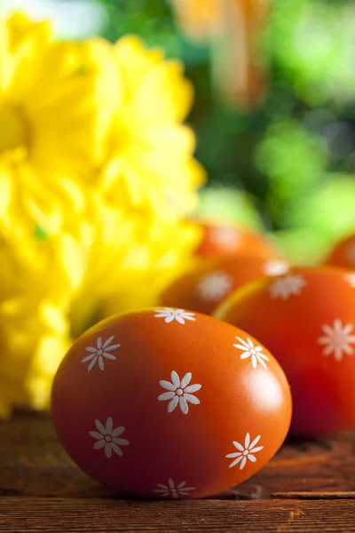 Huevos de Pascua naranja y flores amarillas sobre fondo natural —  Fotos de Stock
