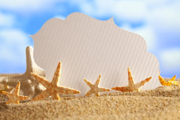 Kağıt kartı ve kum üzerinde starfishes — Stok fotoğraf