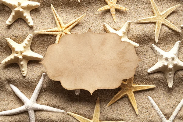 Tarjeta de papel en blanco y estrellas de mar en la playa de verano —  Fotos de Stock