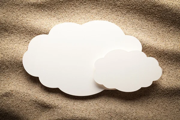Hoja de papel en blanco en forma de nube sobre arena — Foto de Stock