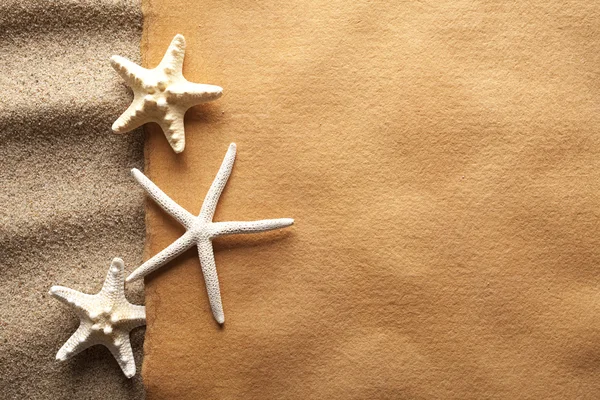 Starfishes e folha de papel artesanal na praia — Fotografia de Stock