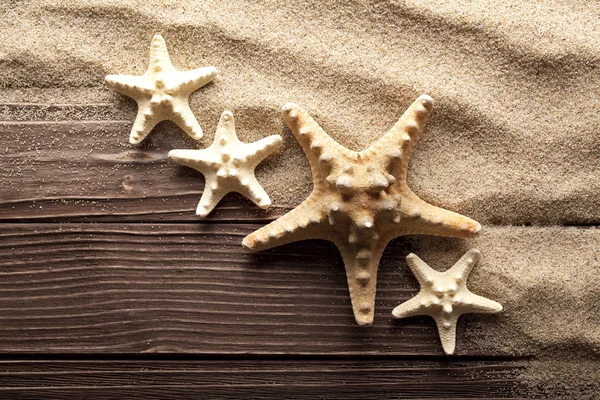 Starfishes em areia e mesa de madeira — Fotografia de Stock