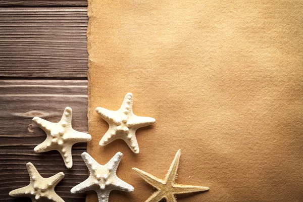 Starfishes e folha de papel artesanal em branco na mesa de madeira — Fotografia de Stock