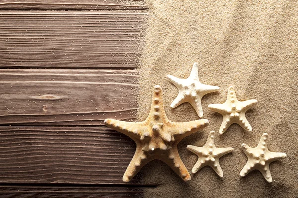 Estrella de mar sobre arena y mesa de madera — Foto de Stock