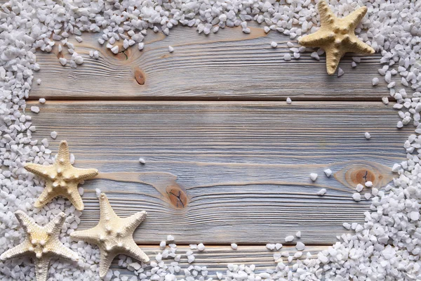 Estrella de mar y piedras sobre fondo de madera — Foto de Stock