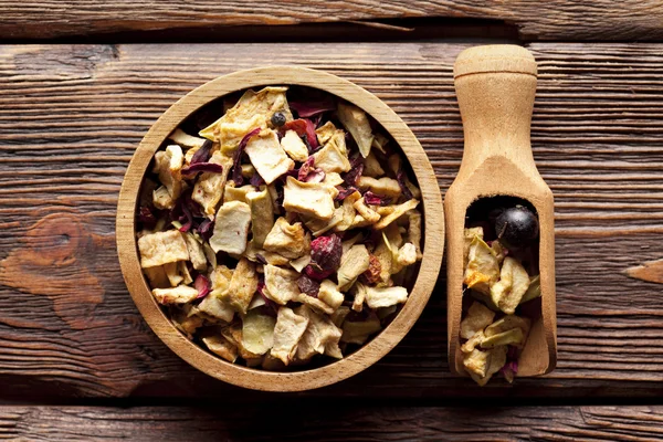 Dried fruit tea mix in a bowl and wooden scoop — Stock Photo, Image
