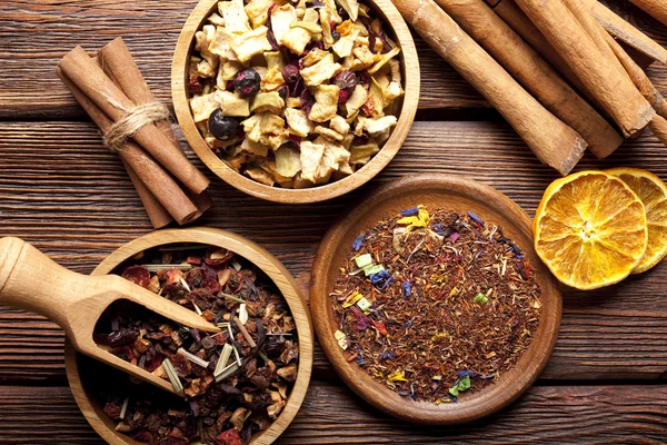 Dried tea leaves, fruits and cinnamon sticks — Stock Photo, Image