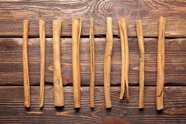 Cinnamon sticks on wooden wall background — Stock Photo, Image