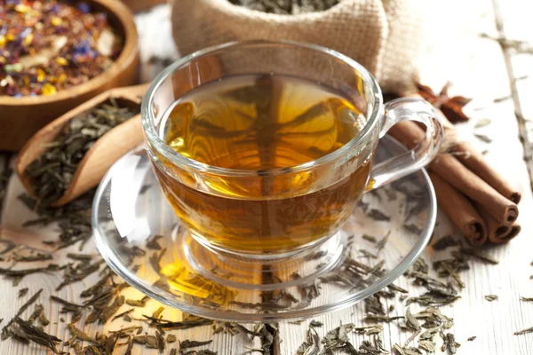 Copa de té y mezcla de hojas de té surtidos en la mesa de madera — Foto de Stock