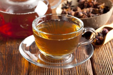 Çeşitli çay yaprakları, fincan çay ve çaydanlık ahşap üzerine