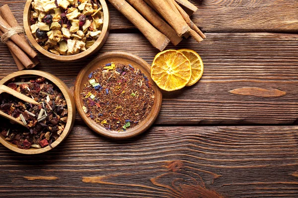 Különféle levelek, a tea és a fűszerek fából készült háttér — Stock Fotó