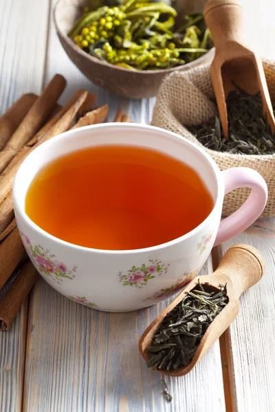 Taza de té y hojas de té secas en tablones de madera — Foto de Stock