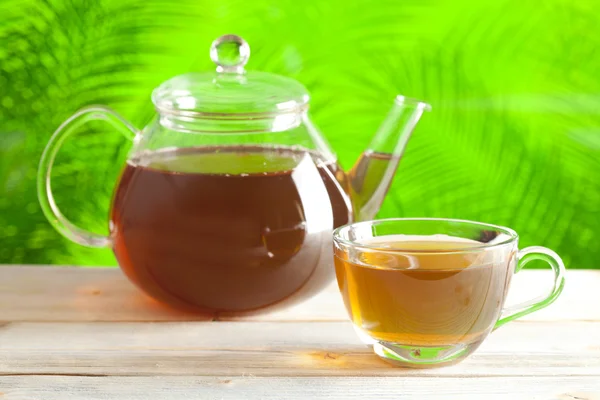 Tasse Tee und Teekanne auf Natur Hintergrund — Stockfoto